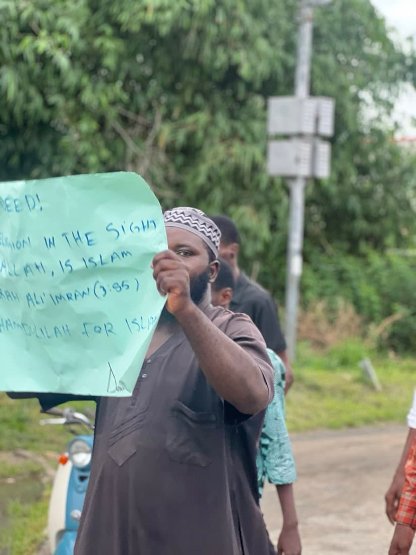 A brother holding up a hand-written placard during the procession