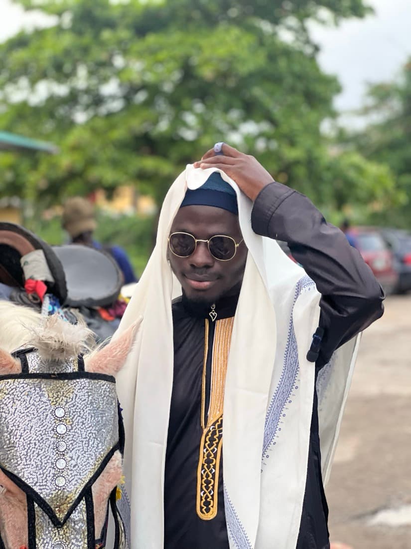 A brother in a white shawl and sunglasses, smiling