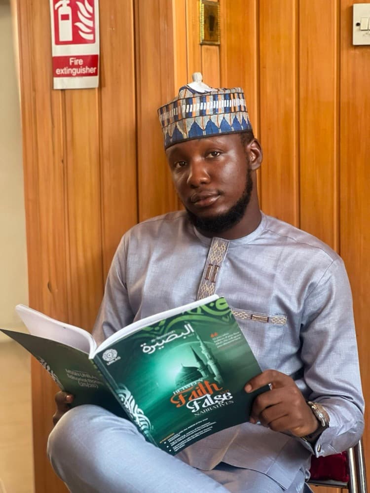 A brother reading the second edition of Al-Baseerah magazine